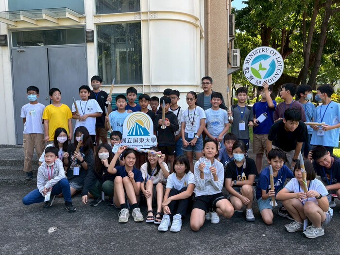 太空科普營隊火箭發射演示前，小朋友拿著自製的紙火箭開心合照圖片